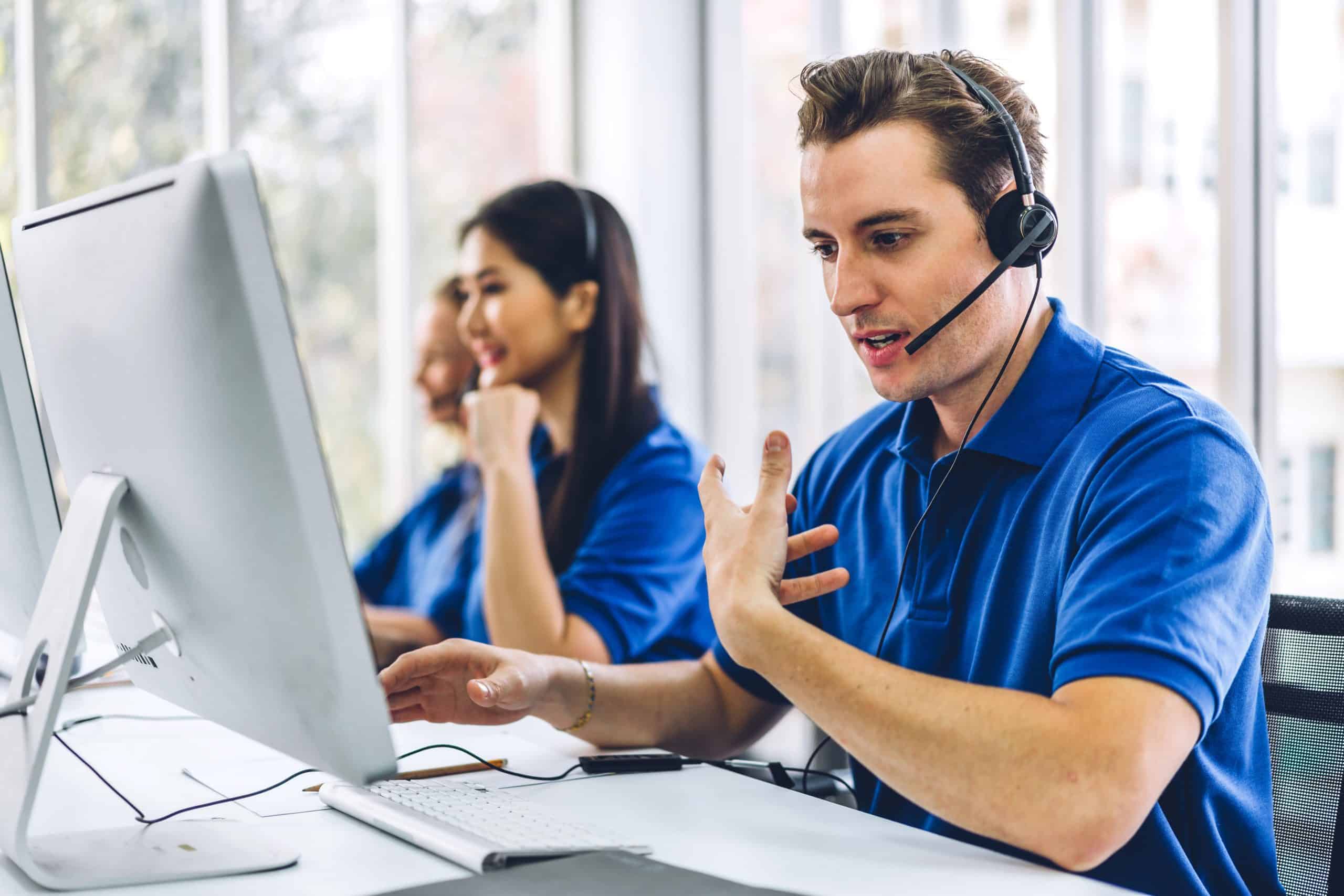  Group of happy call center smiling business operator customer support team phone services agen working and talking with headset on desktop computer at call center 